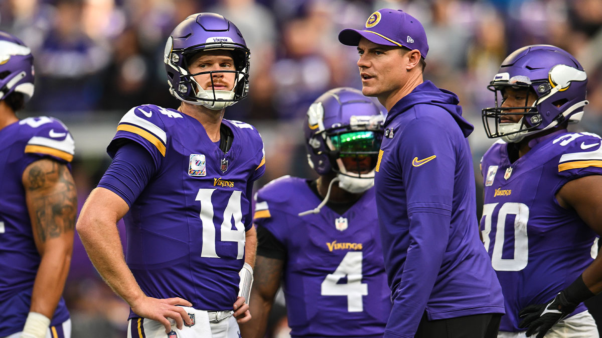 Minnesota Vikings quarterback Sam Darnold (14) and Minnesota Vikings head coach Kevin O'Connell and fullback C.J. Ham (right) look on before the game against the Detroit Lions at U.S. Bank Stadium.