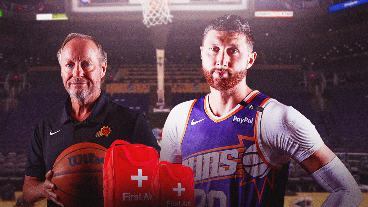 Phoenix Suns center Jusuf Nurkic with first-aid kits around him, while head coach Mike Budenholzer is standing next to him.