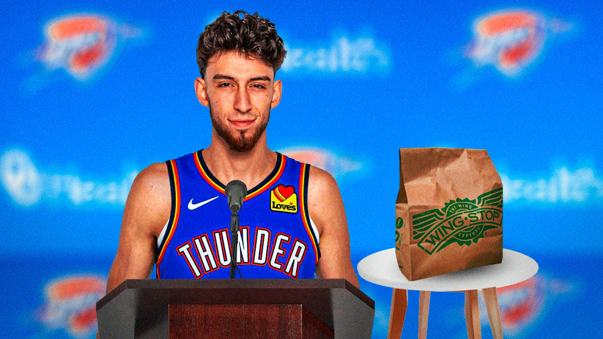 Thunder forward Chet Holmgren smiling behind a podium with a bag of Wing Stop next to him and the Thunder logo in the background
