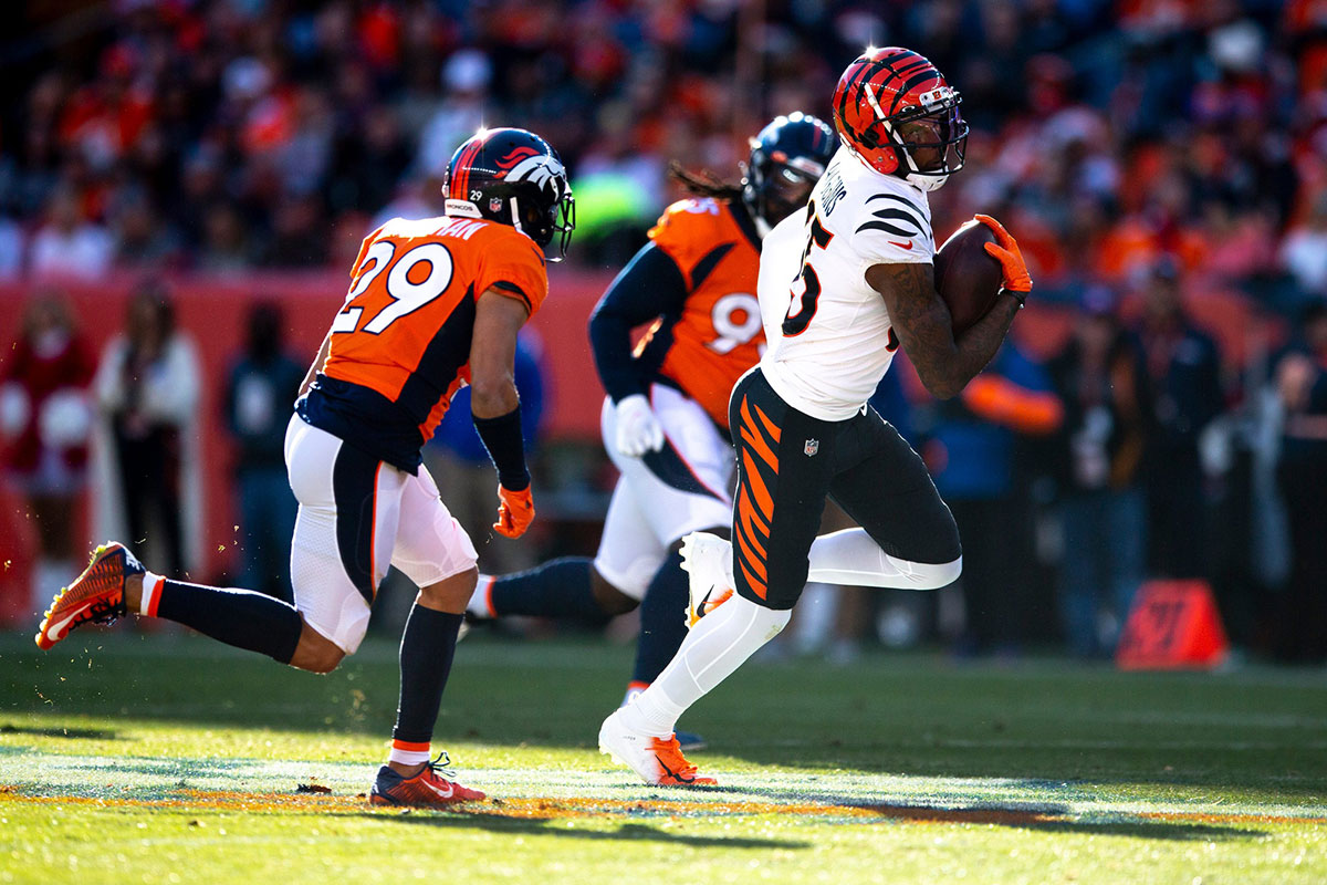 Cincinnati Bengals wide receiver Tee Higgins (85) runs downfield for a first down as Denver Broncos cornerback Bryce Callahan (29) chases in the first half of the NFL football game between the Bengals and the Broncos on Sunday, Dec. 19, 2021, at Empower Field in Denver. Cincinnati Bengals At Denver Broncos 367 Albert Cesare / The Enquirer / USA TODAY NETWORK