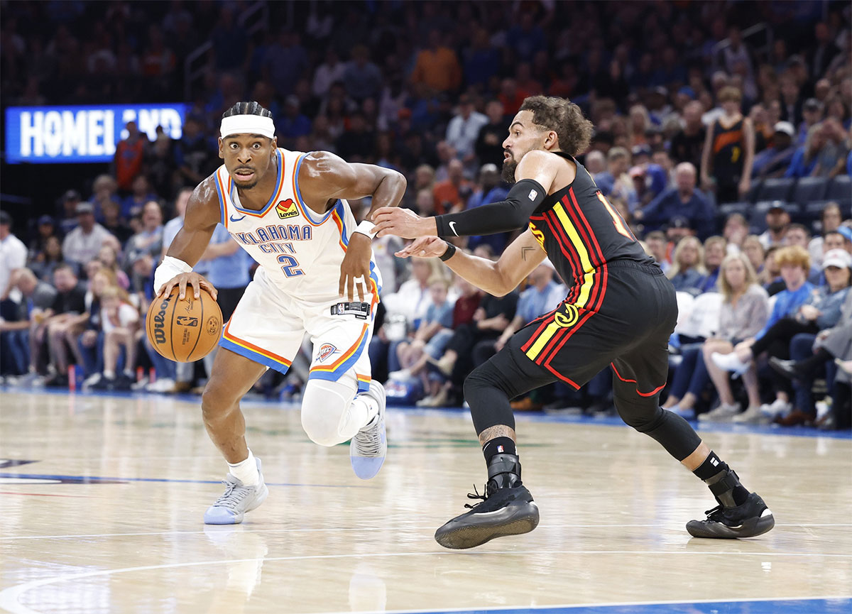 Thunder guard Shai Gilgeous-Alexander (2) drives to the basket around Atlanta Hawks guard Trae Young (11) during the second half at Paycom Center