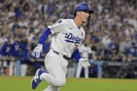Los Angeles Dodgers shortstop Tommy Edman (25) runs after hitting a double in the third inning against the New York Yankees during game two of the 2024 MLB World Series at Dodger Stadium.