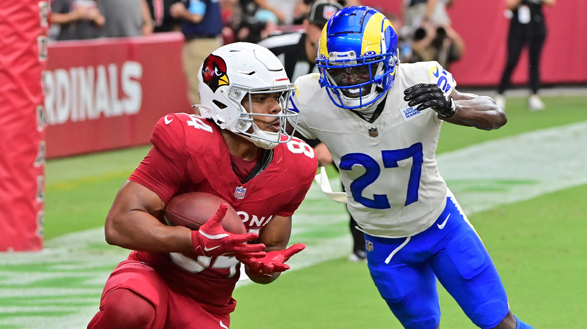 Arizona Cardinals tight end Elijah Higgins (84) catches a touchdown as Los Angeles Rams cornerback Tre'Davious White (27) defends in the first half at State Farm Stadium. 