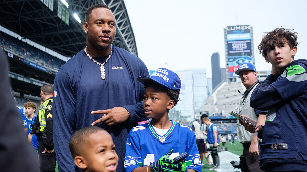 Seattle Seahawks linebacker Uchenna Nwosu (10) takes a photo with fans before the game against Miami Dolphins at Lumen Field.