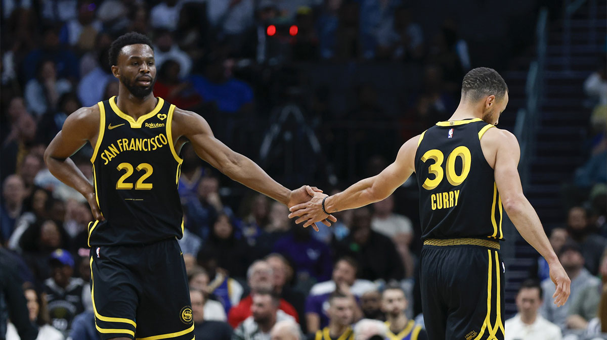 Golden State Warriors forward Andrew Wiggins (22) celebrates with Golden State Warriors guard Stephen Curry (30) after scoring against the Charlotte Hornets during the first quarter at Spectrum Center