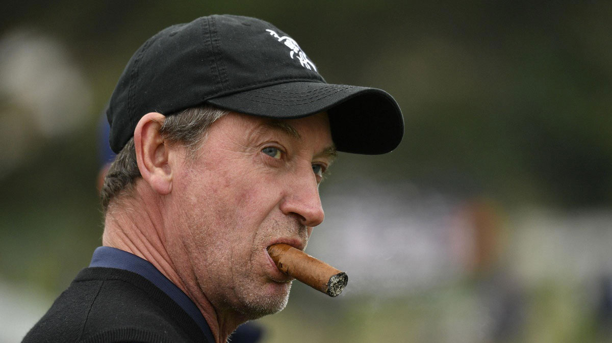 Wayne Gretzky smokes a cigar while surveying the scene at the AT&T Pebble Beach Pro-Am on Feb. 8. Gretzky has been at home with his family in Thousand Oaks, Calif., since the coronavirus pandemic took hold.