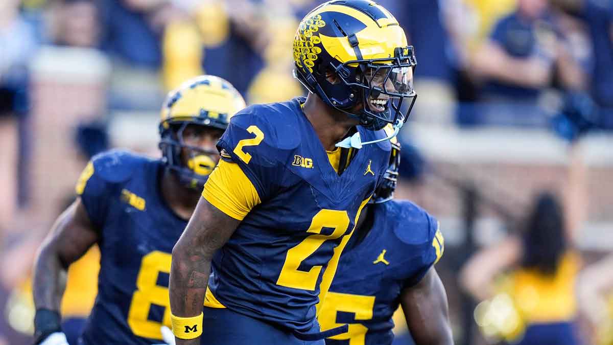 Michigan defensive back Will Johnson (2) celebrates a touchdown after intercepting USC quarterback Miller Moss (7) during the second half at Michigan Stadium