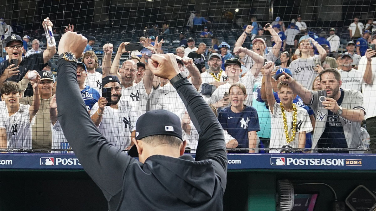 Aaron Boone interacts with Yankees fans during game four of the ALDS for the 2024 MLB Playoffs at Kauffman Stadium.