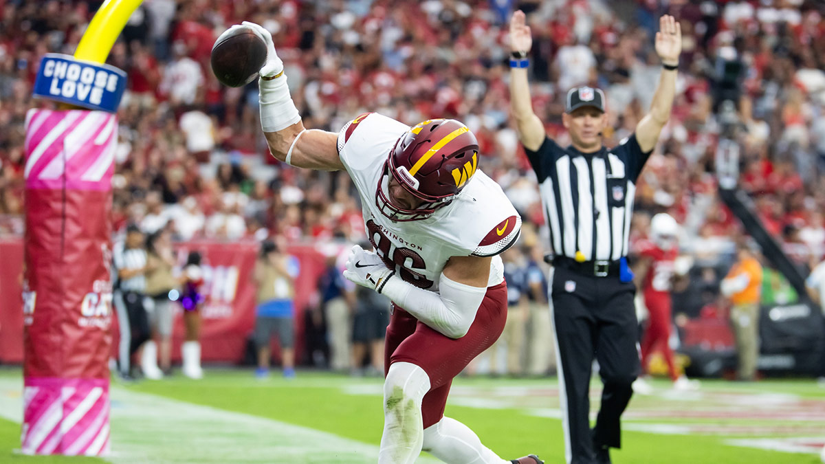 Washington Commanders tight end Zach Ertz (86) spikes the ball as he celebrates a two point conversion against the Arizona Cardinals in the second half at State Farm Stadium