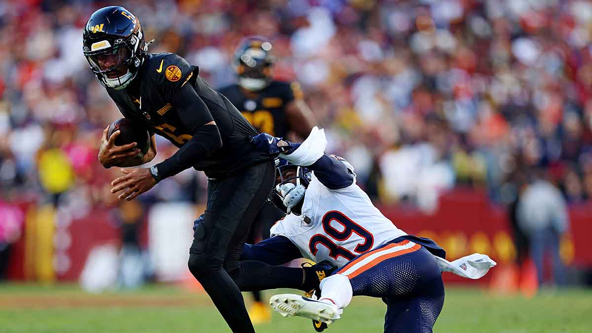 Chicago Bears cornerback Josh Blackwell (39) tackles Washington Commanders quarterback Jayden Daniels (5) during the second quarter at Commanders Field.