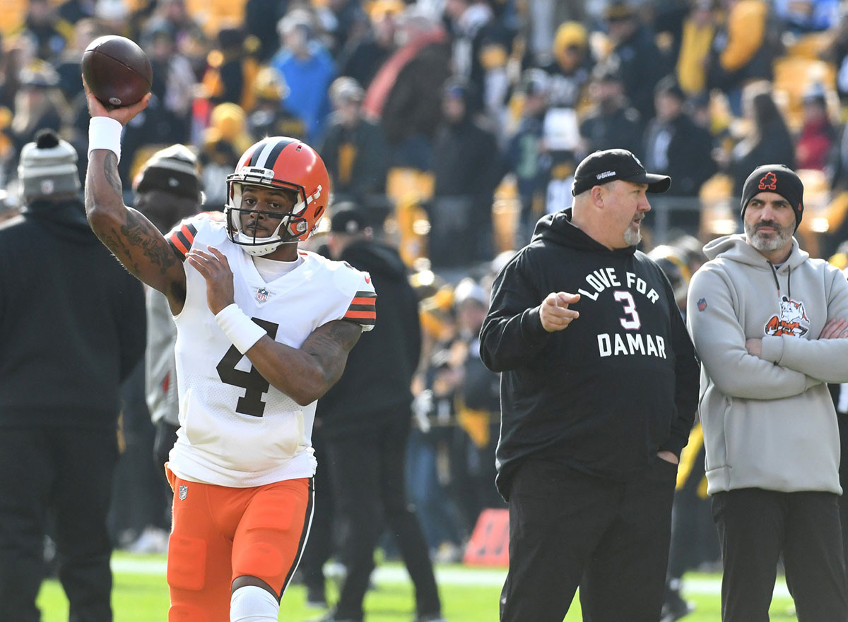 Cleveland Browns quarterback Deshaun Watson (4) throws a practice pass as head coach Kevin Stefanski (right) watches before playing the Pittsburgh Steelers at Acrisure Stadium.