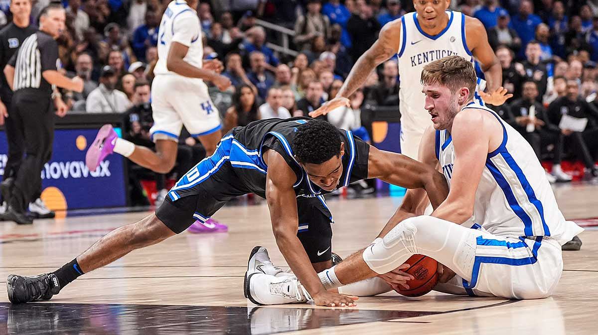 Duke Blue Devils guard Caleb Foster (1) and Kentucky Wildcats forward Andrew Carr (7) fight for the ball at State Farm Arena.