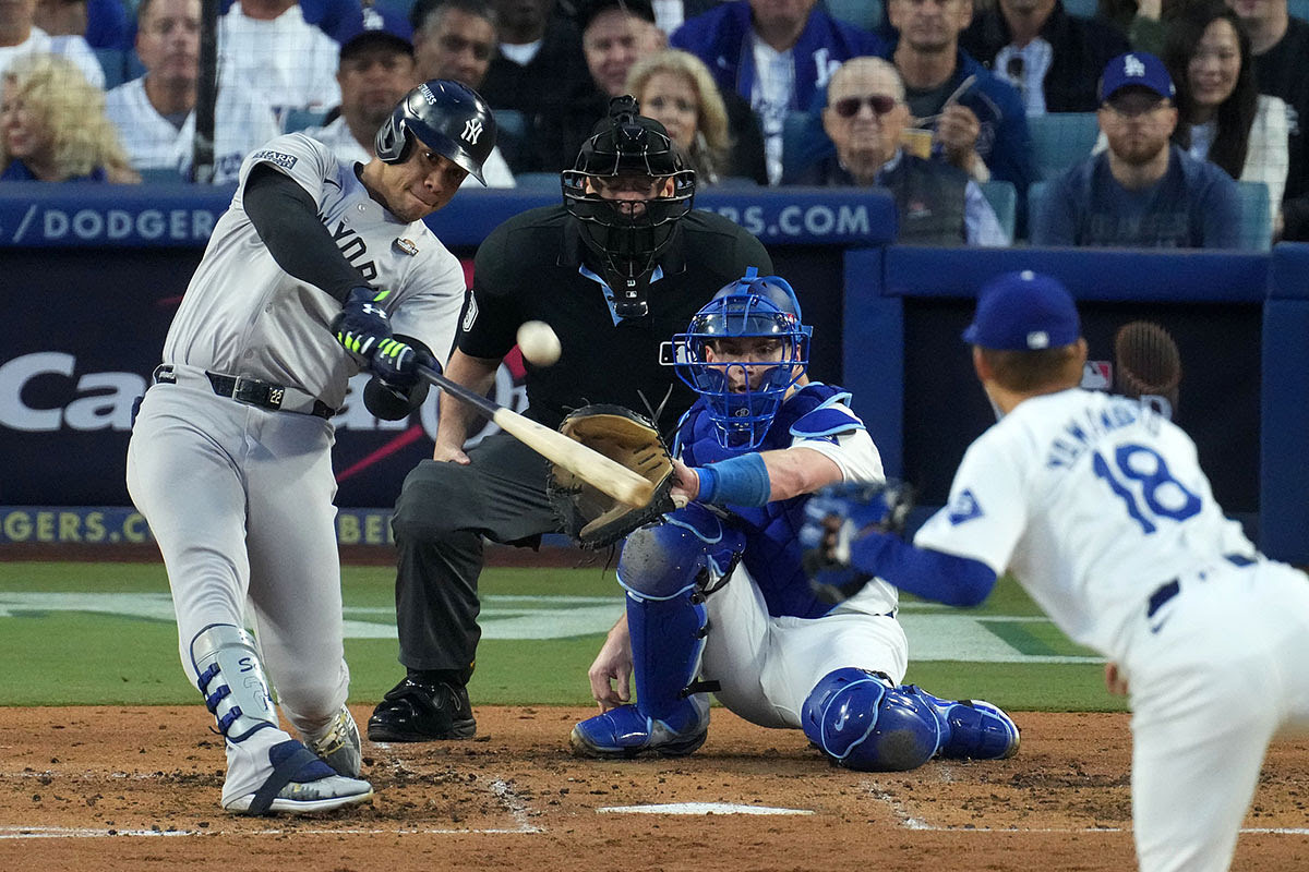 New York Yankees outfielder Juan Soto (22) hits a home run against the Los Angeles Dodgers pitcher Yoshinobu Yamamoto (18) in the third inning for game two of the 2024 MLB World Series at Dodger Stadium.