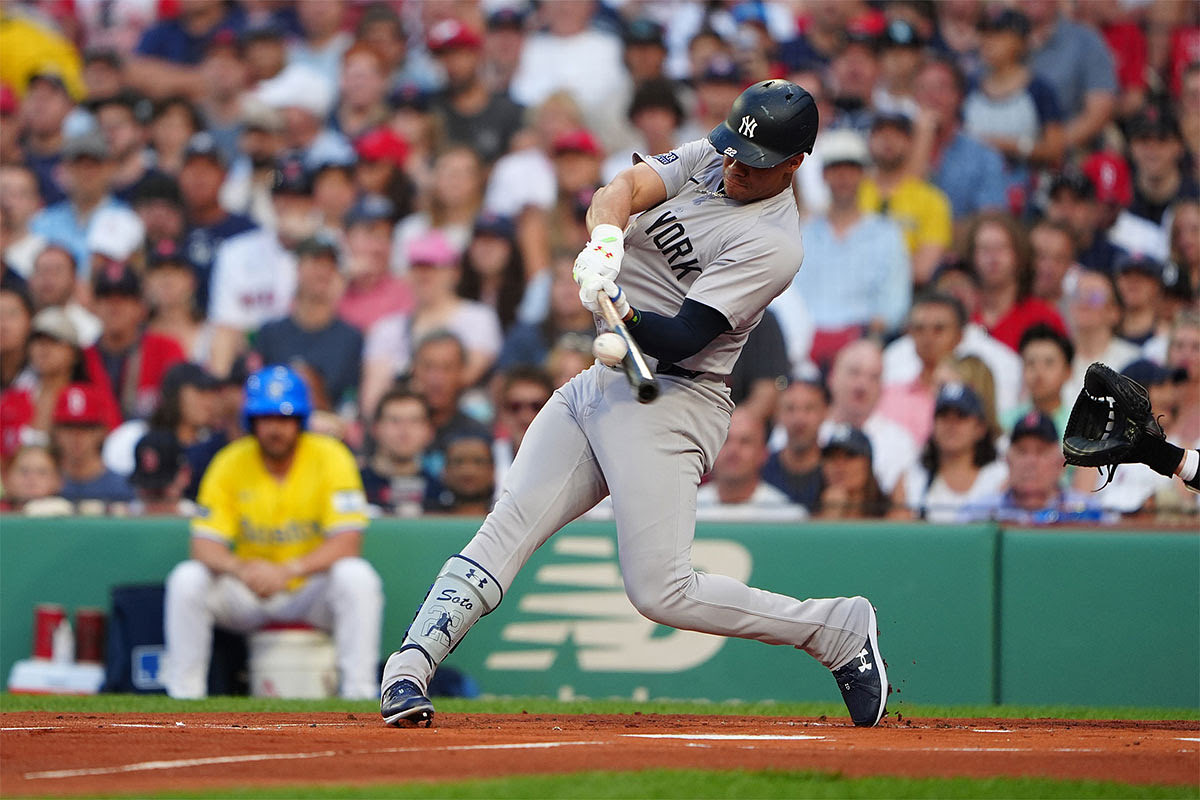 New York Yankees left fielder Juan Soto (22) hits a two-run home run against the Boston Red Sox during the first inning at Fenway Park.