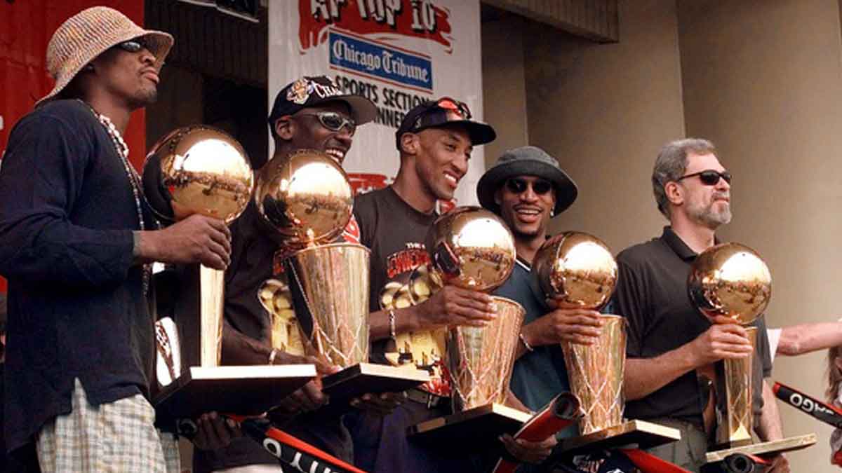 Jun 16, 1997; Chicago, IL, USA; Chicago Bulls players, left to right, Ron Harper, Dennis Rodman, Scottie Pippen, Michael Jordan & coach Phil Jackson hold up the Bulls' five championship trophies at a rally in Grant Park.