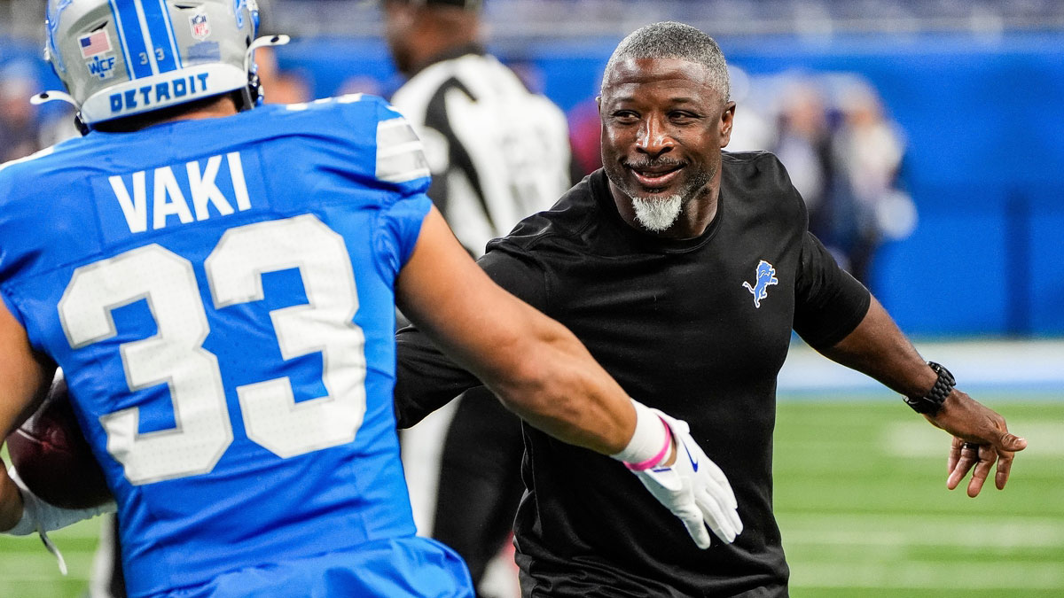 Detroit Lions defensive coordinator Aaron Glenn shakes hands with running back Sione Vaki (33) during warm up before the Tennessee Titans game at Ford Field in Detroit on Sunday, Oct. 27, 2024.
