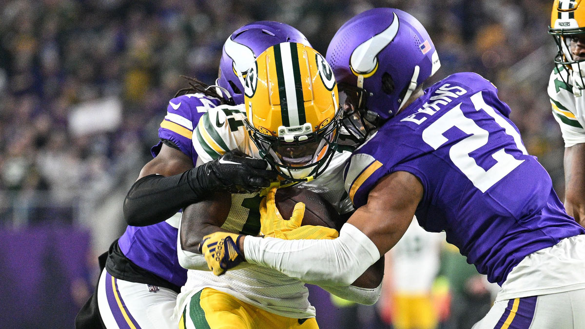 Dec 31, 2023; Minneapolis, Minnesota, USA; Green Bay Packers wide receiver Jayden Reed (11) scores a touchdown as Minnesota Vikings cornerback Akayleb Evans (21) and safety Camryn Bynum (24) attempt to make the tackle during the second quarter at U.S. Bank Stadium.