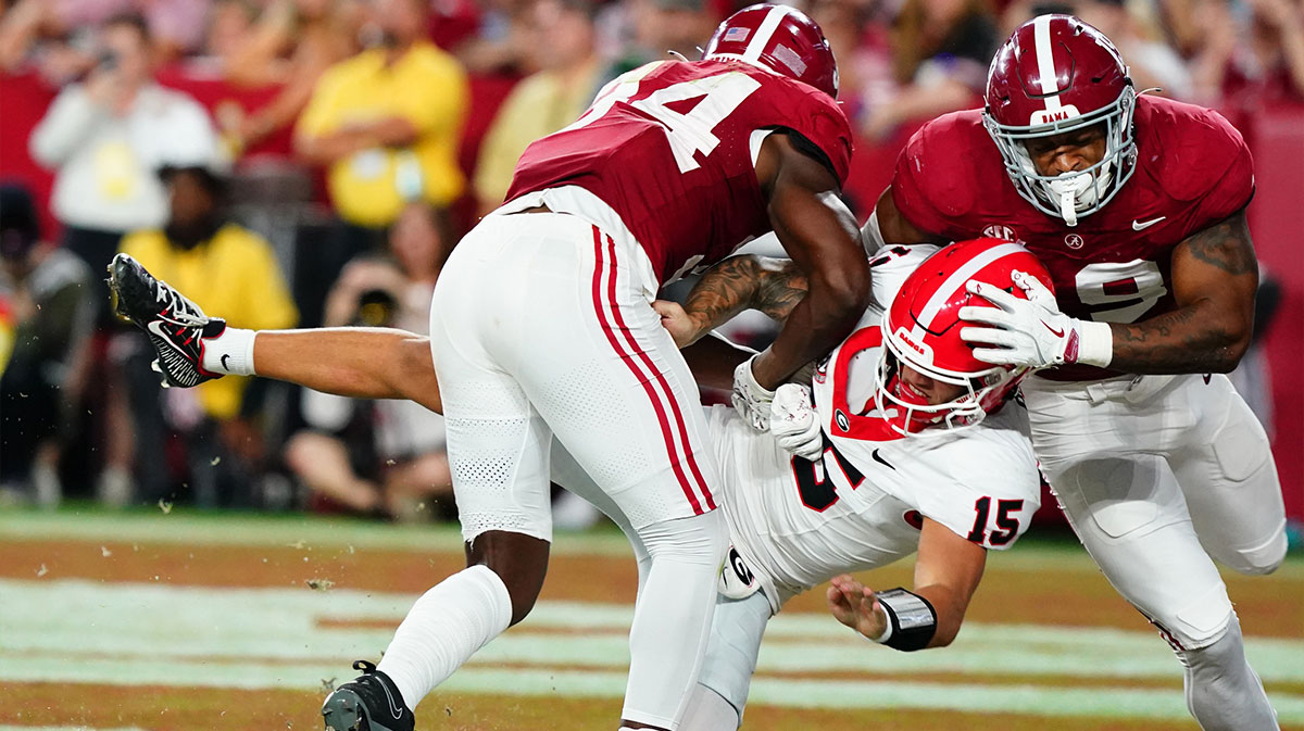 Georgia Bulldogs quarterback Carson Beck (15) is hit in the end zone by Alabama Crimson Tide linebacker Que Robinson (34) and linebacker Keanu Koht (19) after throwing a pass during the first half at Bryant-Denny Stadium.
