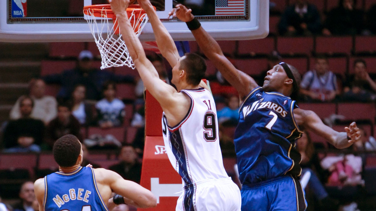 New Jersey Nets forward Yi Jianlian (9) gets a slam dunk during the second half against Washington Wizards forward Andray Blatche (7) and center JaVale McGee (34) at the Izod Center. Washington Wizards defeat the New Jersey Nets by a score of 89-85.