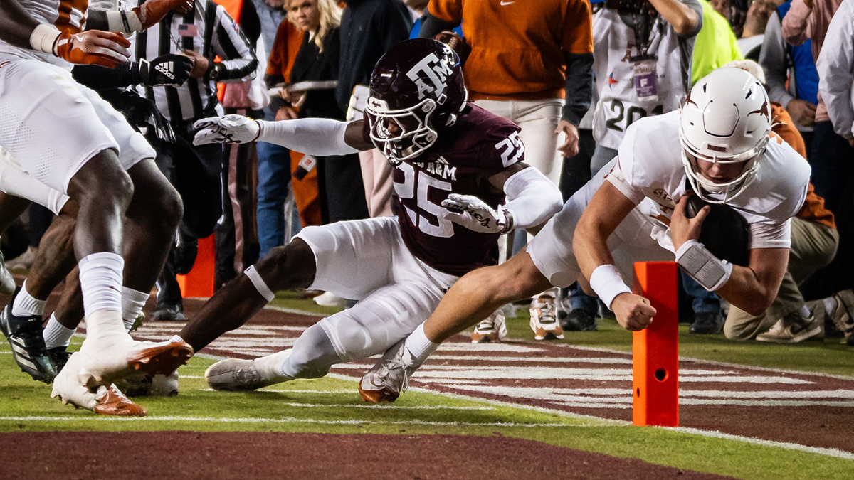 Texas Longhorns quarterback Arch Manning (16) dives for a touchdown against Texas A&M Aggies defensive back Dalton Brooks (25) in the first quarter at Kyle Field. The touchdown was awarded after a review of the play.