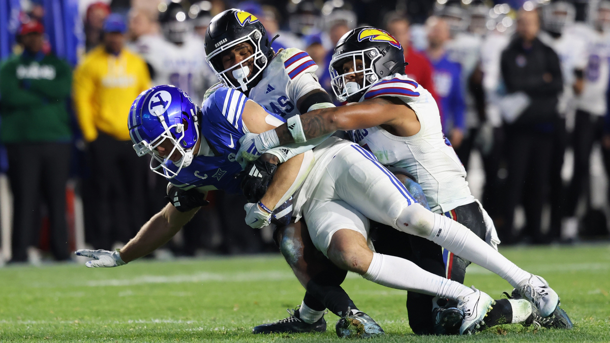Brigham Young Cougars wide receiver Chase Roberts (2) is tackled short of a first by Kansas Jayhawks safety Marvin Grant (center) and linebacker Cornell Wheeler (44) to turn the ball over on downs during the fourth quarter at LaVell Edwards Stadium.