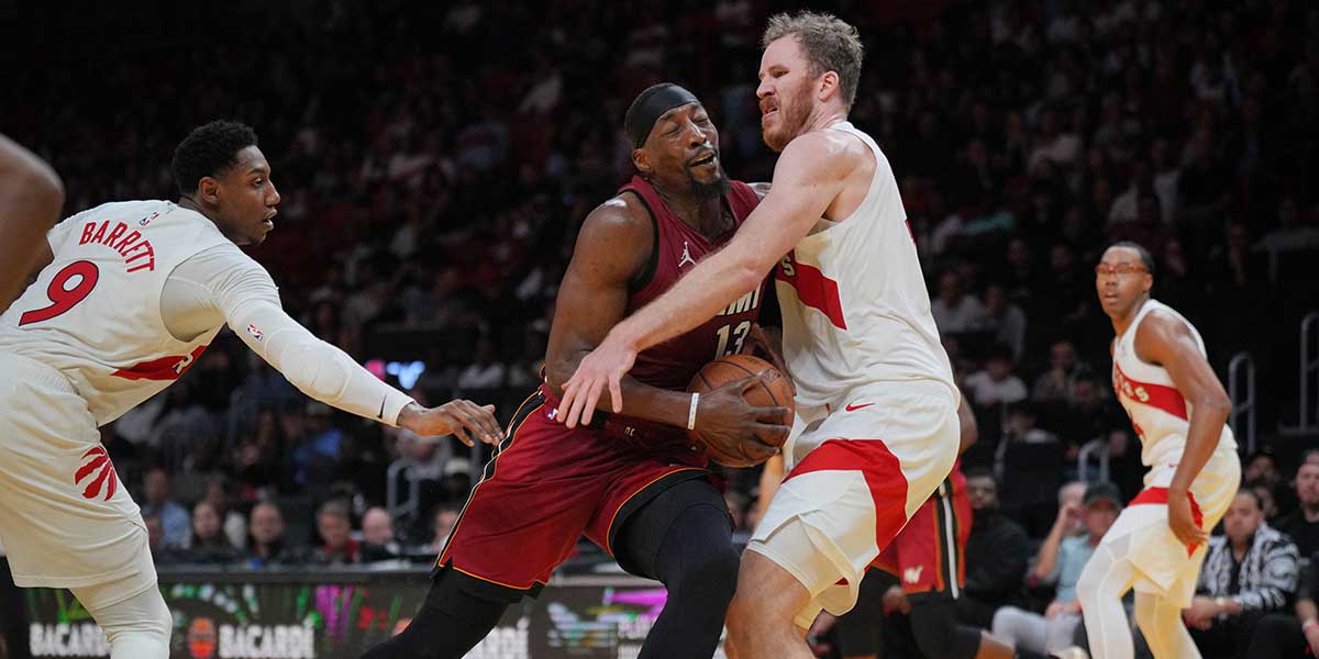 Miami Heat center Bam Adebayo (13) collides with Toronto Raptors center Jakob Poeltl (19) during the second half in an NBA Cup game at Kaseya Center.