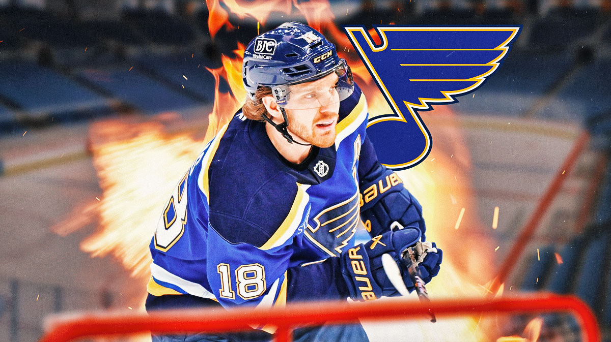 Robert Thomas looking happy with fire around him, St. Louis Blues logo, hockey rink in background