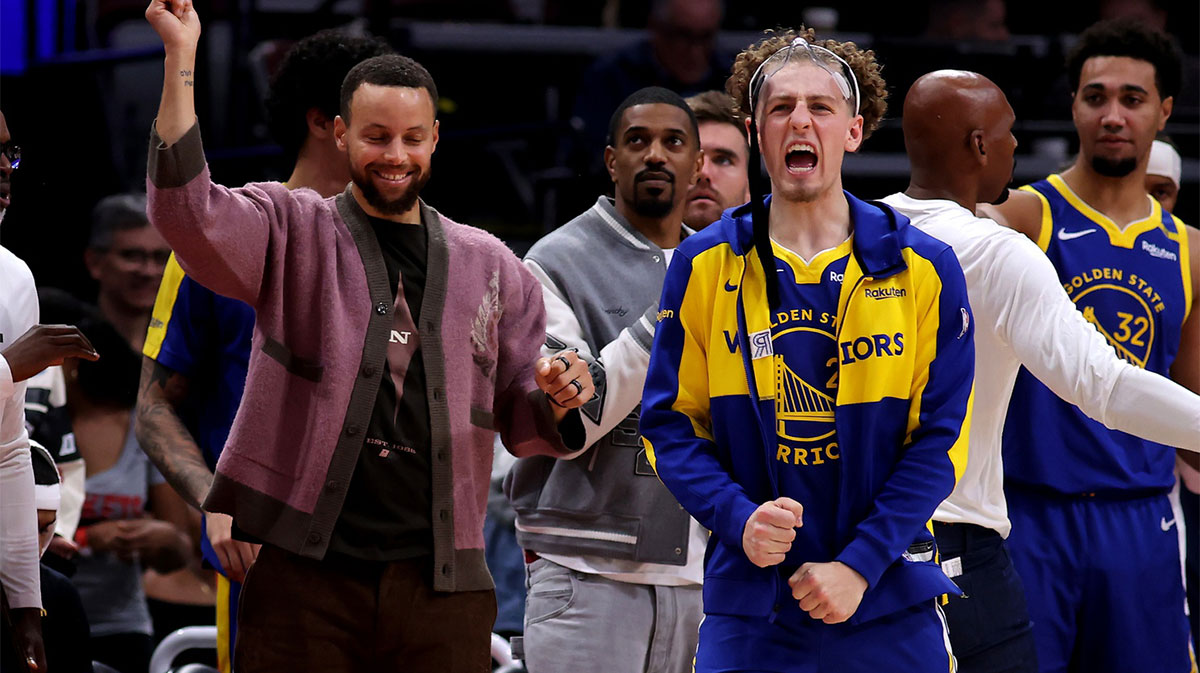 Golden State Warriors guards Stephen Curry and guard Brandin Podziemski (2) react on the bench after a made basket against the Houston Rockets during the overtime period at Toyota Center.