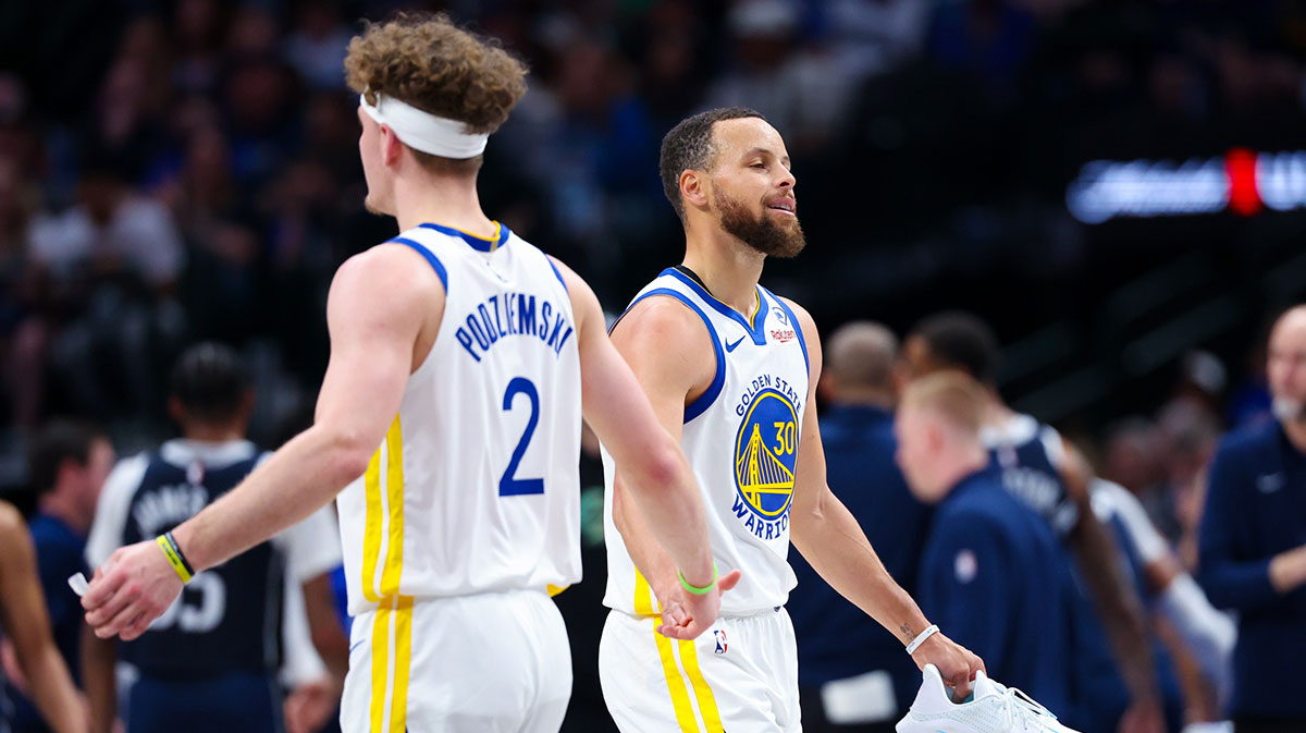 Golden State Warriors guard Stephen Curry (30) reacts with Golden State Warriors guard Brandin Podziemski (2) after losing his shoe during the first half against the Dallas Mavericks at American Airlines Center.