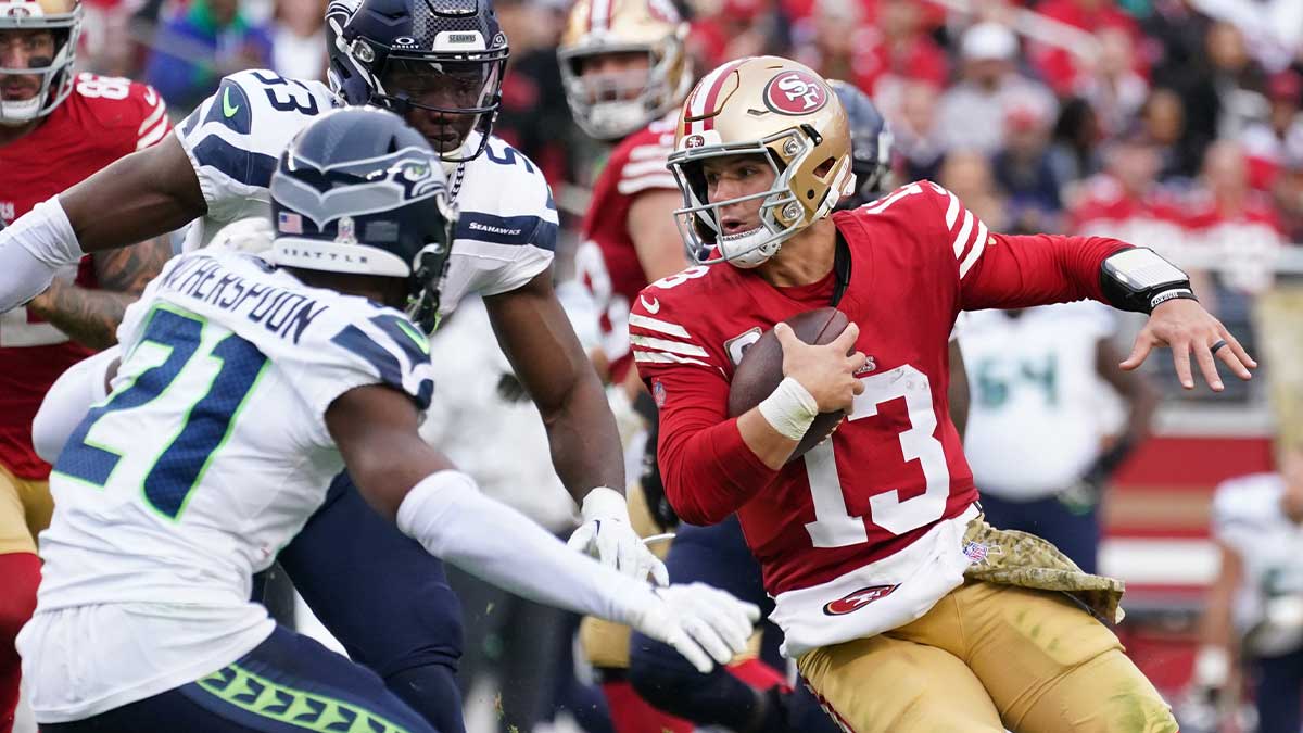 San Francisco 49ers quarterback Brock Purdy (13) scrambles away from Seattle Seahawks cornerback Devon Witherspoon (21) in the third quarter at Levi's Stadium.