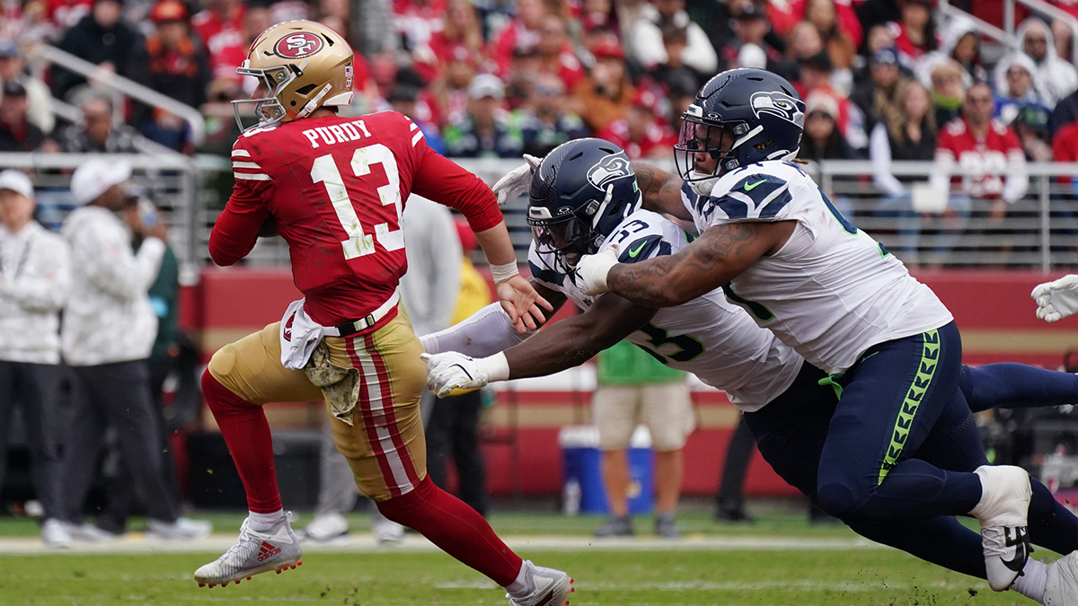 San Francisco 49ers quarterback Brock Purdy (13) scrambles away from Seattle Seahawks linebacker Boye Mafe (53) and Seattle Seahawks defensive tackle Byron Murphy II (91) in the third quarter at Levi's Stadium. Purdy's status remains unclear for Packers-49ers on Week 12.