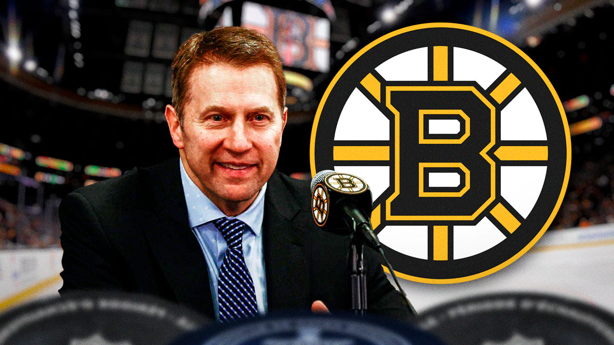 Joe Sacco in image looking happy, Boston Bruins logo, hockey rink in background
