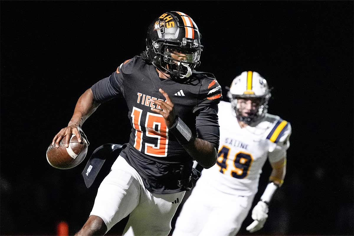 Belleville quarterback Bryce Underwood keeps the ball and runs against Saline during the second half of district final at Belleville High School