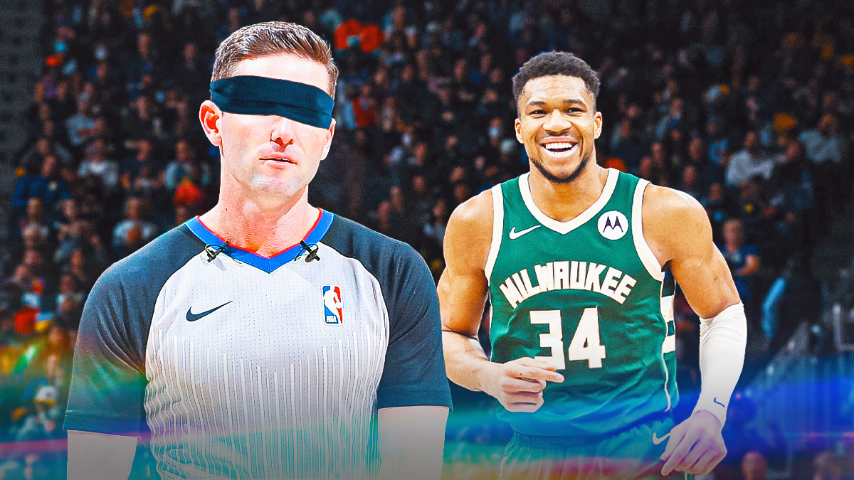 Referee Ben Taylor with a blindfold on, with Bucks' Giannis Antetokounmpo laughing