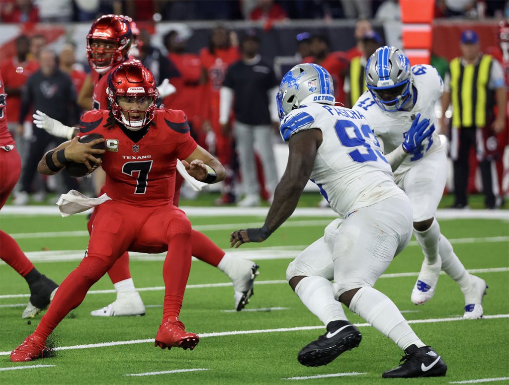 Houston Texans quarterback C.J. Stroud (7) scrambles from Detroit Lions defensive end Josh Paschal (93) in the second half at NRG Stadium.