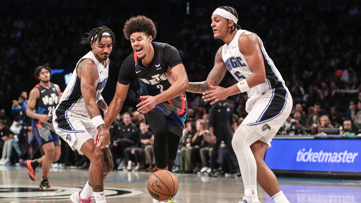 Brooklyn Nets forward Cameron Johnson (2) loses the ball after attempting to drive in between Orlando Magic guard Gary Harris (14) and forward Paolo Banchero (5) in the third quarter at Barclays Center.