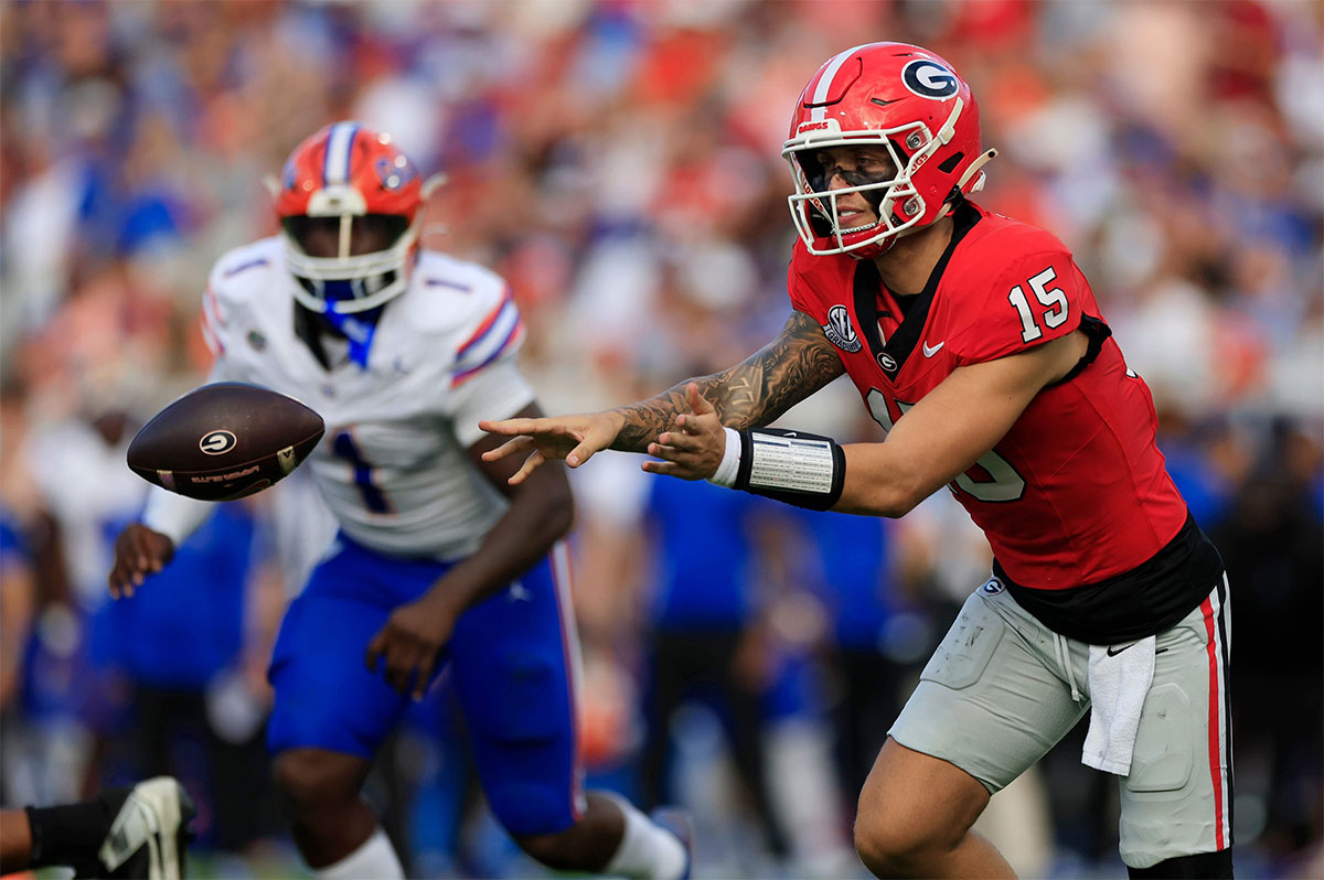 Georgia Bulldogs quarterback Carson Beck (15) pitches the ball during the second quarter of an NCAA college football matchup Saturday, Nov. 2, 2024 at EverBank Stadium in Jacksonville, Fla. The Georgia Bulldogs defeated the Florida Gators 34-20.