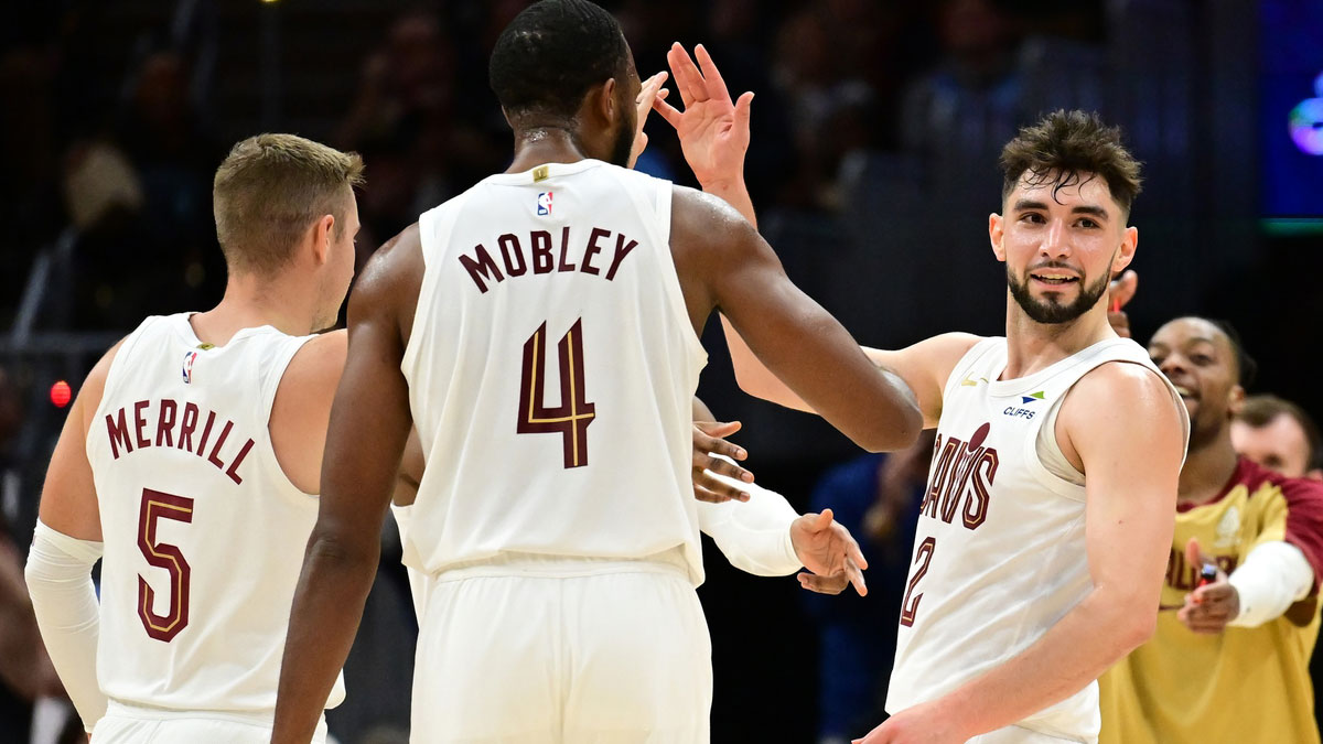 Cleveland Cavaliers guard Ty Jerome (2) celebrates after hitting a three point basket with guard Sam Merrill (5) and forward Evan Mobley (4) during the second half against the Toronto Raptors at Rocket Mortgage FieldHouse.