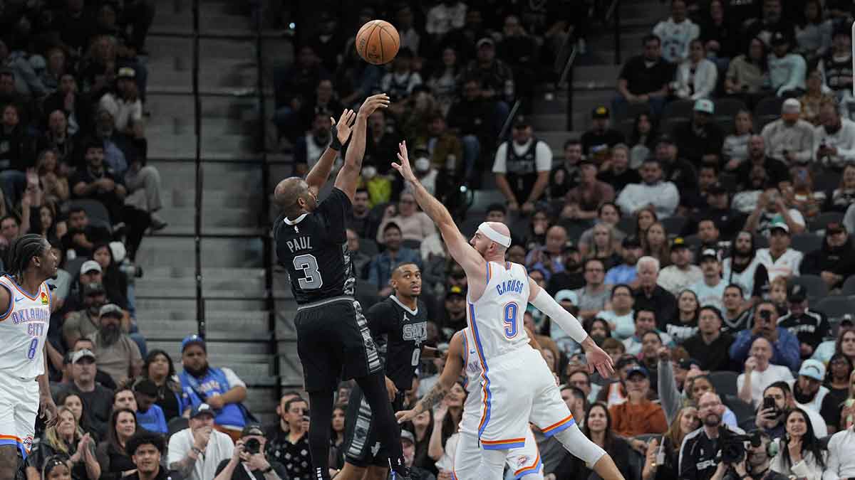 San Antonio Spurs guard Chris Paul (3) shoots over Oklahoma City Thunder guard Alex Caruso (9) in the second half at Frost Bank Center.