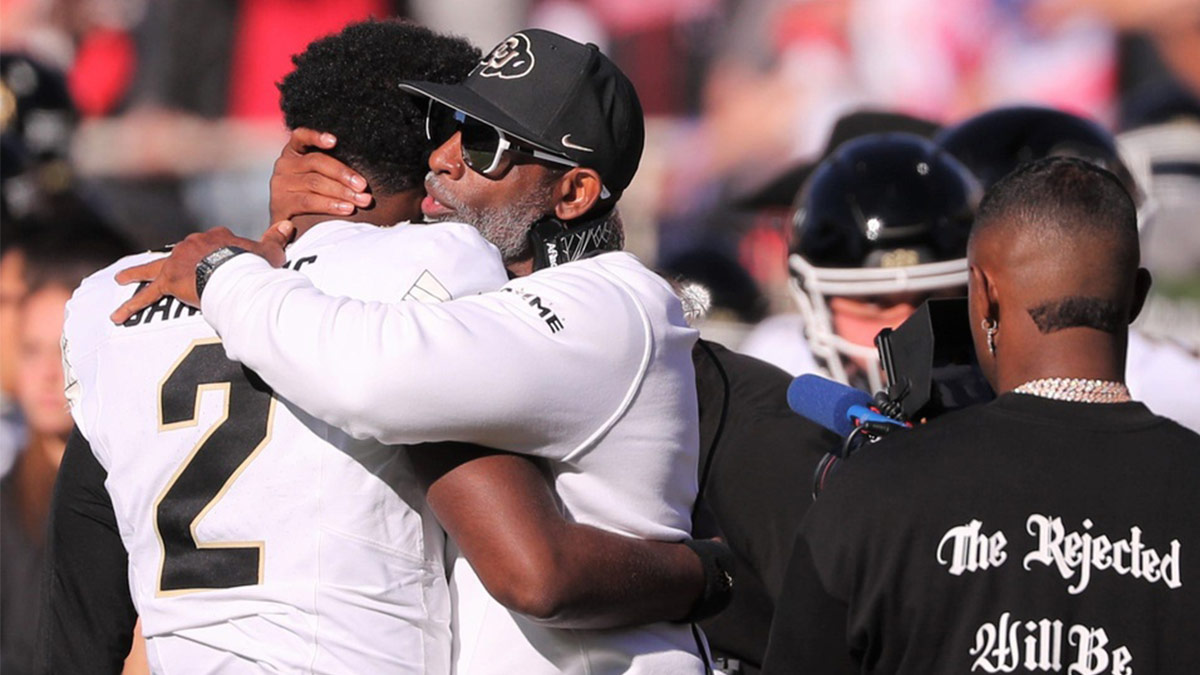 Colorado football coach Deion Sanders hugs his son, Shedeur Sanders, before facing Texas Tech.