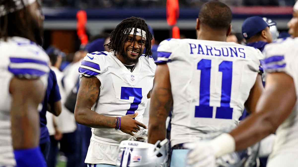 Dallas Cowboys cornerback Trevon Diggs (7) smiles while talking with linebacker Micah Parsons (11) on the sideline during the fourth quarter of their game against the Philadelphia Eagles at AT&T Stadium
