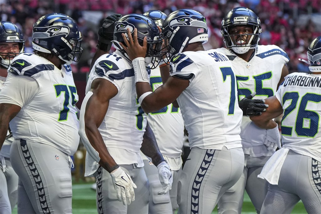 Seattle Seahawks wide receiver DK Metcalf (14) reacts with quarterback Geno Smith (7) after catching a touchdown pass against the Atlanta Falcons during the first half at Mercedes-Benz Stadium.