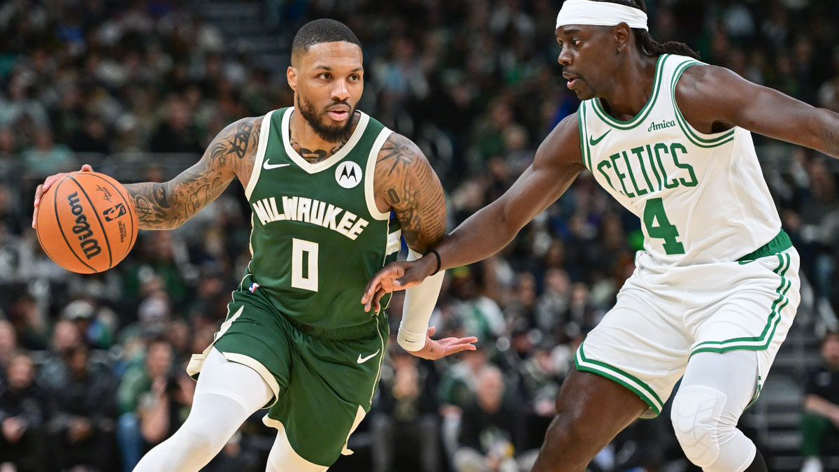 Milwaukee Bucks guard Damian Lillard (0) drives for the basket against Boston Celtics guard Jrue Holiday (4) in the first quarter at Fiserv Forum.