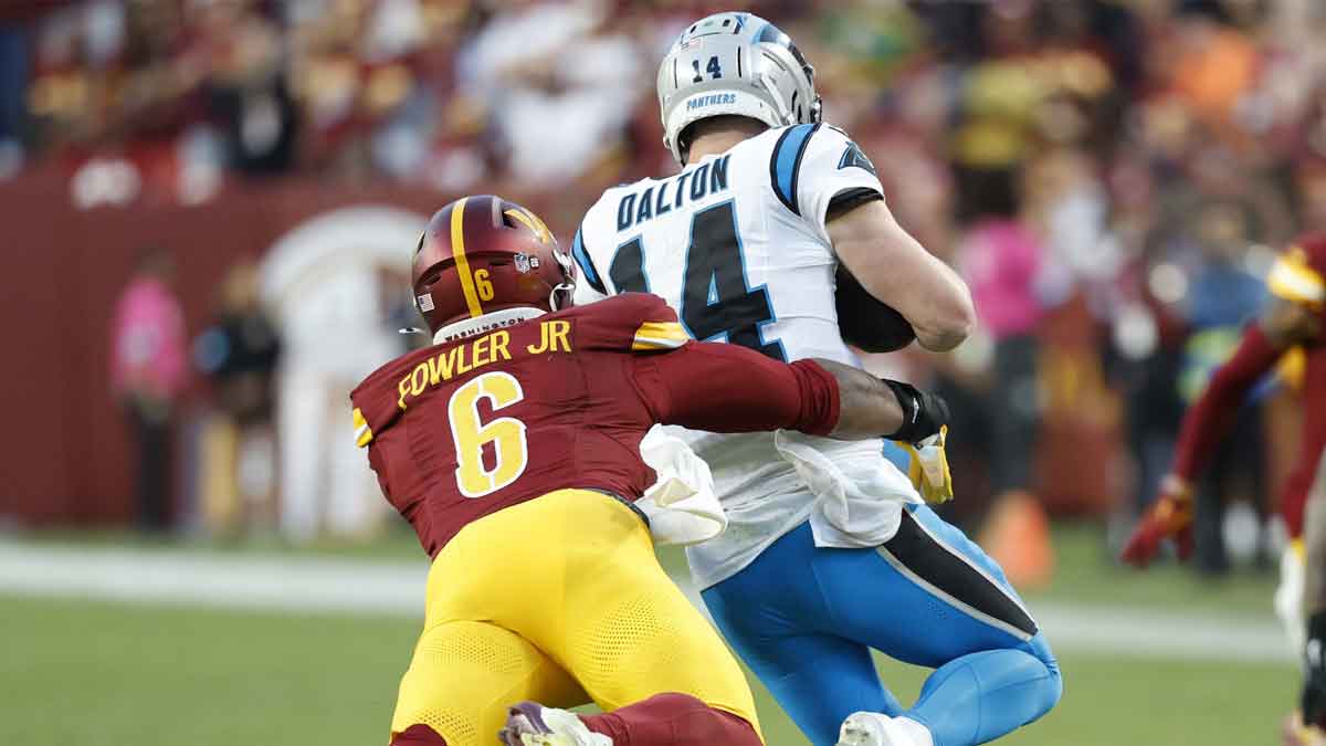 Oct 20, 2024; Landover, Maryland, USA; Carolina Panthers quarterback Andy Dalton (14). Is tackled by Washington Commanders linebacker Dante Fowler Jr. (6) during the fourth quarter at Northwest Stadium. 