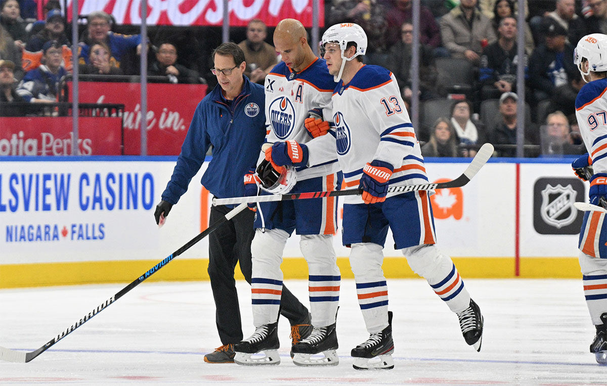 Edmonton Oilers defenseman Darnell Nurse (25) is helped off the ice after suffering an apparent injury on a bodycheck from Toronto Maple Leafs forward Ryan Reaves (not shown) in the second period at Scotiabank Arena. 