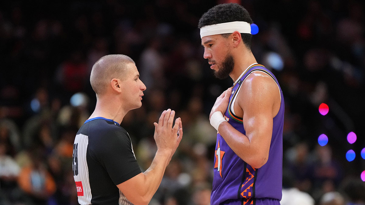 Phoenix Suns guard Devin Booker (1) talks to referee Tyler Ford (39) during the first half of an NBA game against the Orlando Magic at Footprint Center.