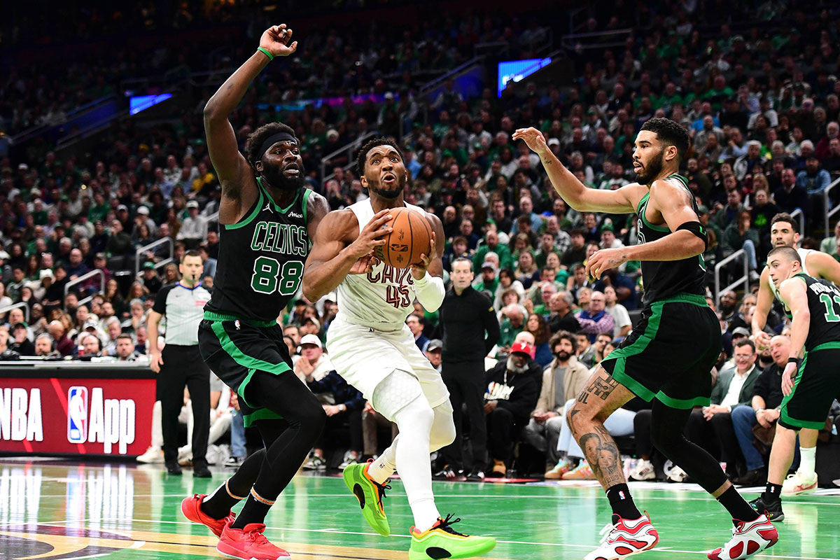 Cleveland Cavaliers guard Donovan Mitchell (45) drives to the basket between Boston Celtics center Neemias Queta (88) and forward Jayson Tatum (0) during the second half at TD Garden