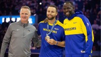 Golden State Warriors guard Stephen Curry (center) is flanked by head coach Steve Kerr and forward Draymond Green as he is presented his gold medal for his performance for Team USA at the 2024 Summer Olympics in Paris before taking on the Sacramento Kings at Chase Center.