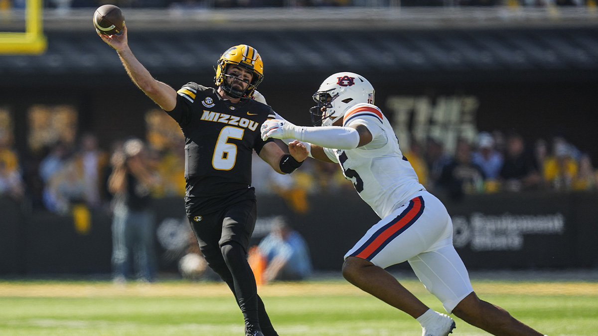 Missouri Tigers quarterback Drew Pyne (6) throws a pass against Auburn Tigers defensive lineman Keldric Faulk (15) during the first half at Faurot Field at Memorial Stadium. 