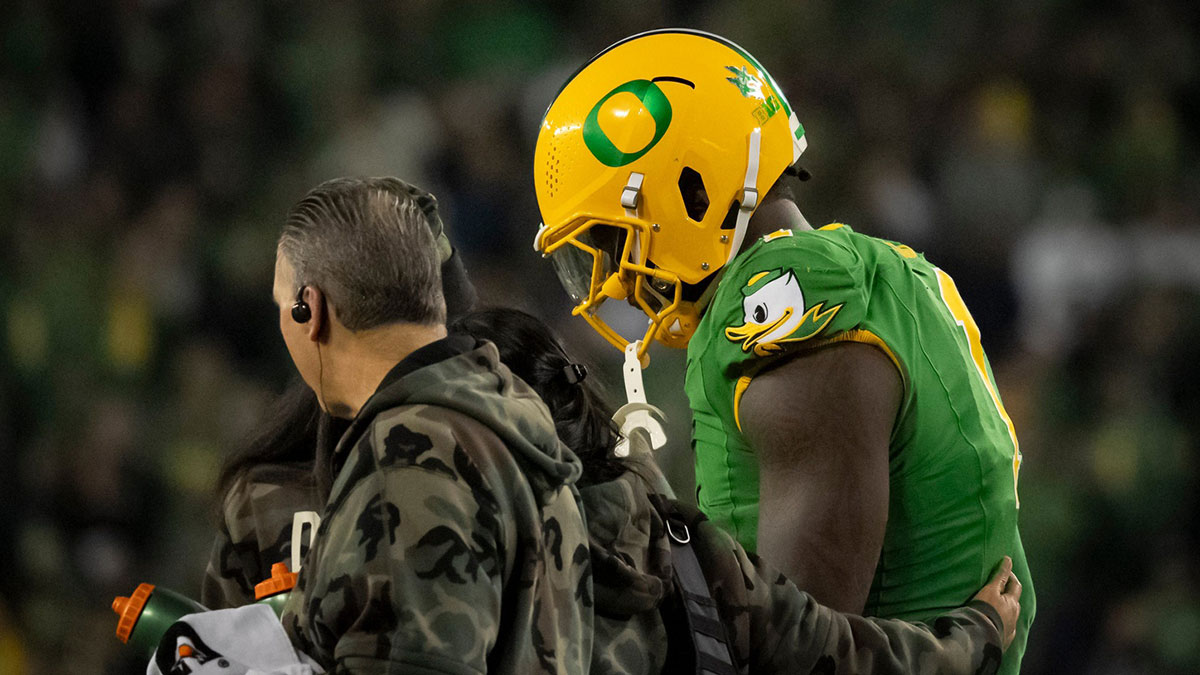 Oregon defensive end Jordan Burch is helped off the field as the Oregon Ducks host the Maryland Terrapins at Autzen Stadium Saturday